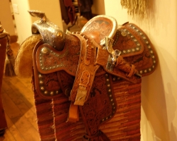 Historic saddle with holster and revolver in living room